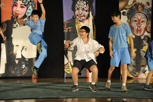 Students on stage imitate stunts in front of the Guo Guang Opera Company